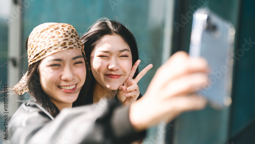 фотографія Two young asian woman sibling gen z taking selfie photo share travel moment on s