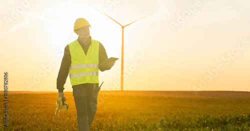 Canvas Print Engineer with digital tablet works on a field of wind turbines