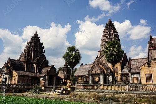 A stunning view of an ancient sanctuary, featuring a grand central Prang (tower) decorated with meticulous stone carvings.