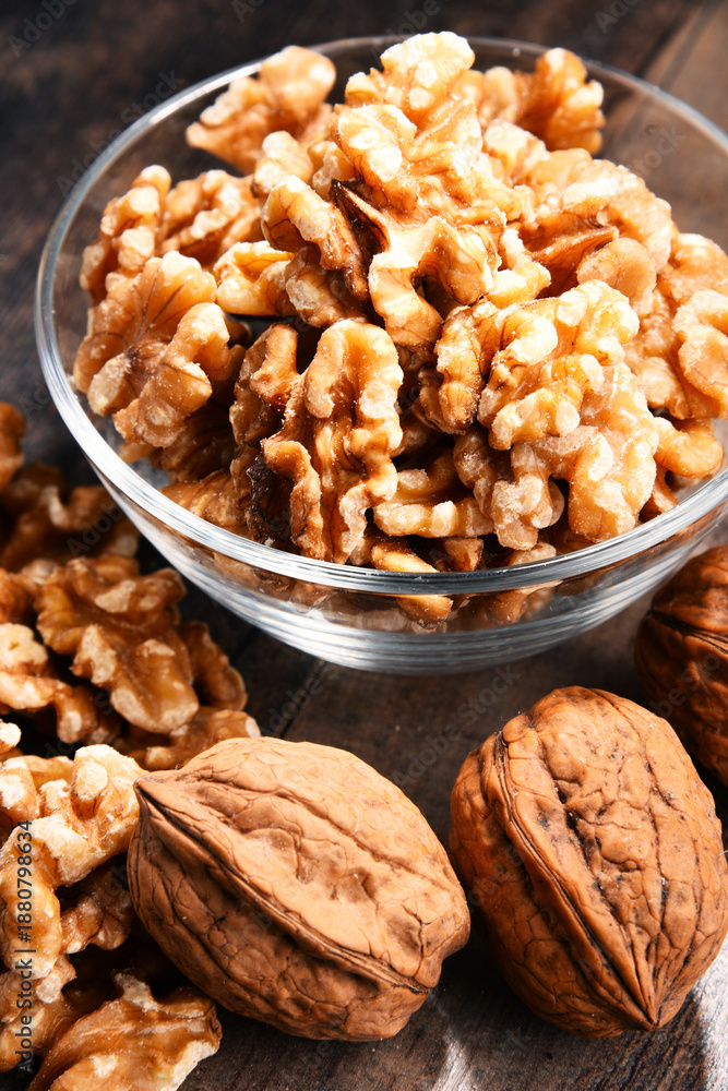 Obraz premium Bowl with Persian walnut on wooden table