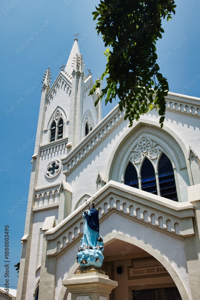 Fototapeta premium A striking white church serves as an iconic cultural and religious landmark in Puerto Princesa, Palawan, Philippines. Its clean façade and classic design stand out against the surrounding city.