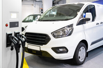 Fotobehang Voertuigen Elektrische bestelwagen bij laadstation stad  © scharfsinn86