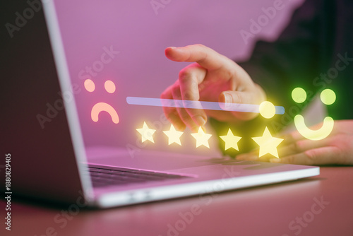 User providing feedback on a laptop with rating stars and emoticons in a modern workspace setting