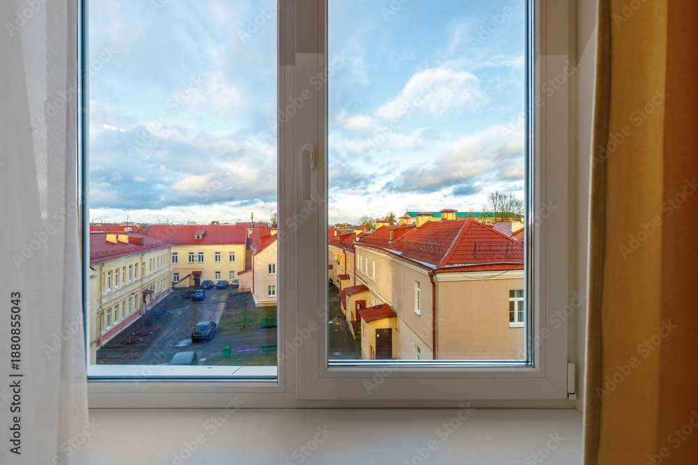 Fototapeta premium View through a white plastic window of an old town European street