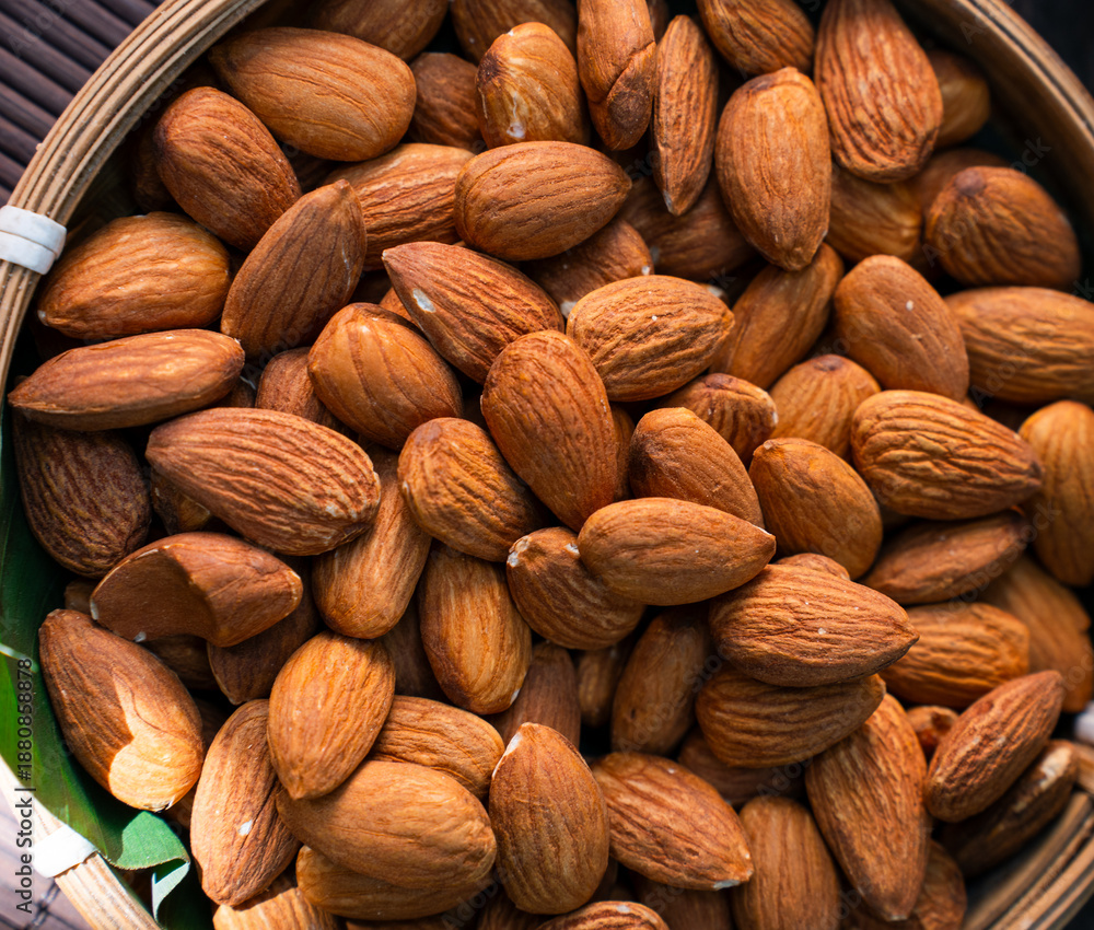 Fototapeta premium Close up of roasted almonds filling a woven basket