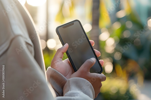 Hands holding smartphone with blank screen, clean modern lifestyle mockup