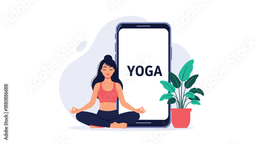 Young woman in a lotus yoga pose meditating in front of a large smartphone with the word 'YOGA' on screen, a modern online class concept.