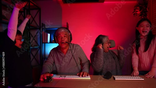 Win winner, Happy Emotional family playing games on computer at home. Asian Grandfather and grand daughter playing video games. enjoying time together indoors, Family leisure activity with children