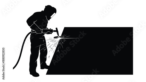 A welder working on a metal sheet depicted in stark silhouette