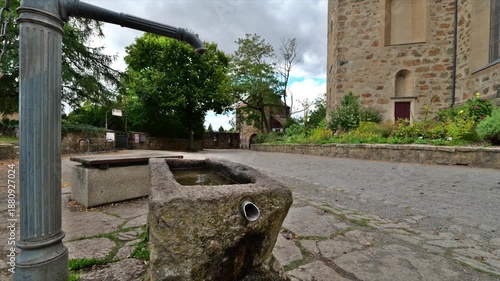 Historic fountain with old pump next to Michaeliskirche in Bautzen, Germany. Stone trough with flowing water