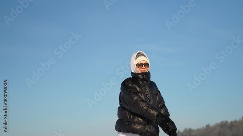 A girl launches a children's airplane into the sky on a sunny winter day.