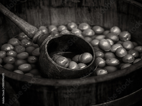 Tableau sur toile Black and white sepia toned retro image of Wooden barrel of green olives with la