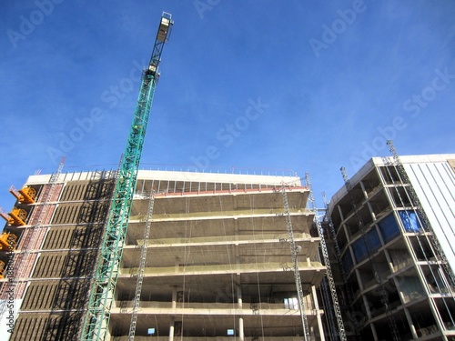 building under construction with green crane