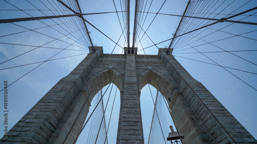 Naklejka premium Brooklyn Bridge stone pillars captured from below highlighting structural details and grandeur