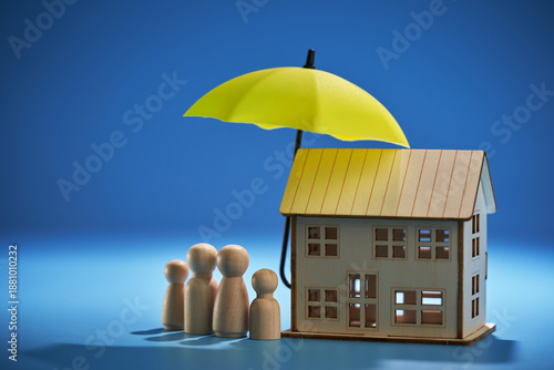 property and family insurance concept Miniature figures of a family stand next to a houses