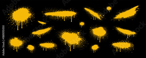 Set of yellow spray paint splatters and drips on a black background, featuring urban graffiti style textures and artistic splashes for design.