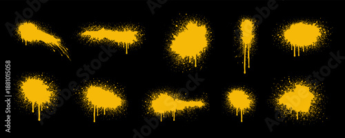 Set of yellow spray paint splatters, drips, and splashes on black. Graffiti style design elements for urban art and grunge textures.
