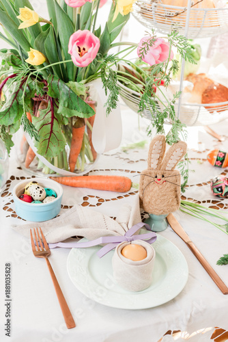 Easter table close up detail. Easter bunny egg cosy and folded napkin decorations for festive Sunday breakfast