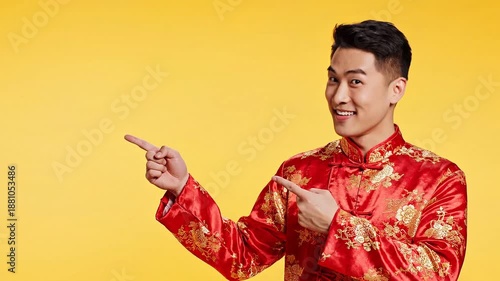 Young Asian man in traditional red Chinese clothing pointing excitedly