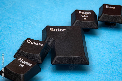 Abstract representation features scattered keyboard keys. Keys are including Enter and Delete, resting upon blue surface. Emphasizing foundational technology and vintage hardware. Selective focus.