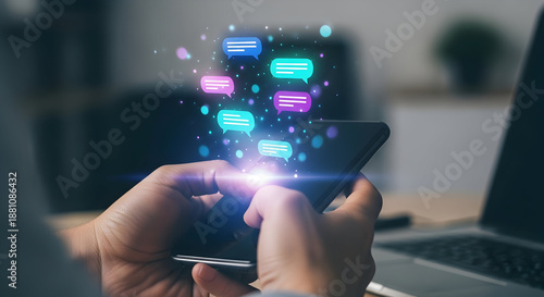 Person holding a smartphone with colorful speech bubbles and text messages floating above in an office.