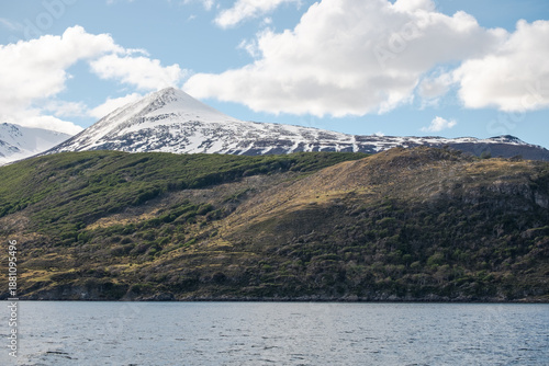 Nature scenery with fresh snow on the mountain and the forested hills towards the Beagle Channel in Ushuaia, Argentina
