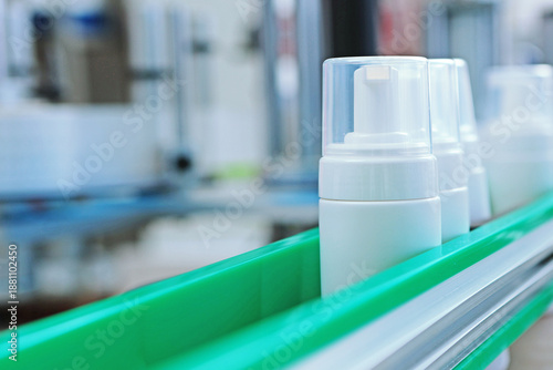 Slika na platnu White plastic bottles move along conveyor belt