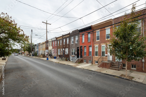 Street level view of a road and a long line of rowhouses without cars in a South Philadelphia neighborhood, Pennsylvania, USA