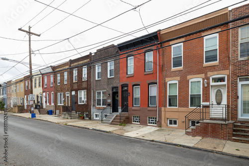 Street level view of a road and a long line of rowhouses without cars in a South Philadelphia neighborhood, Pennsylvania, USA