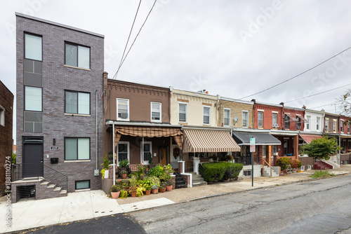 Street level view of a road and a long line of rowhouses without cars in a South Philadelphia neighborhood, Pennsylvania, USA