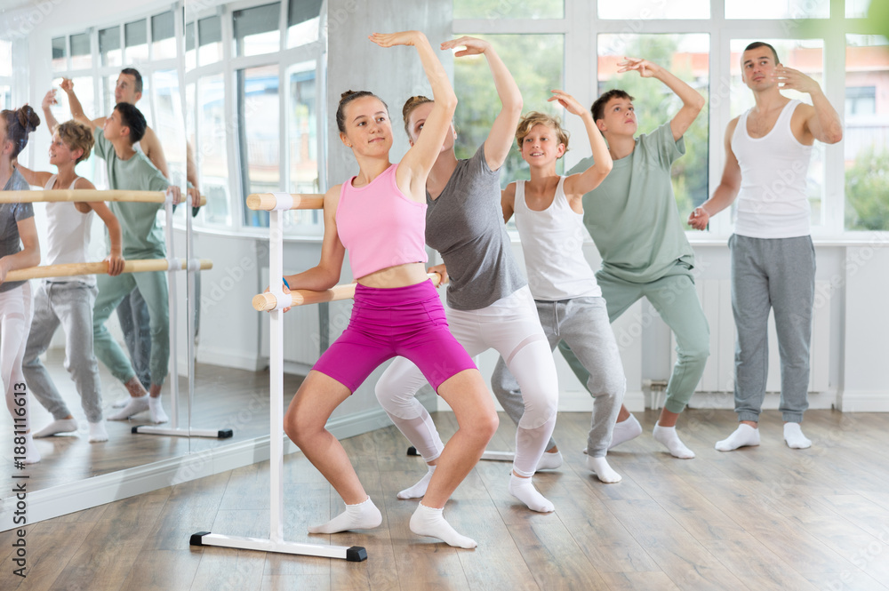 Fototapeta premium Ballet lesson for teenagers - choreographer teaches girls and boys ballet steps