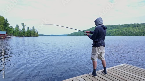 Man using finesse fishing angling style technique with light tackle rod, line, and lure with bobber. Angler setting the hook or hooking the fish during summer vacation fishing.