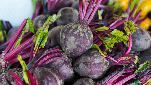 A bunch of purple beets with green leaves