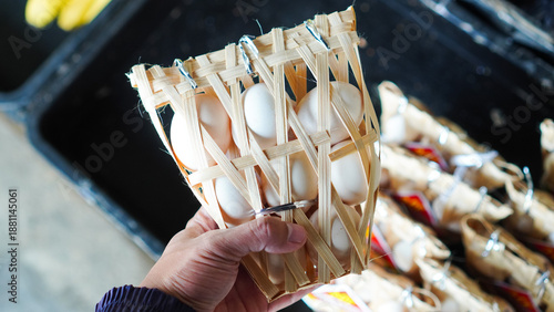 A person is holding a basket of eggs