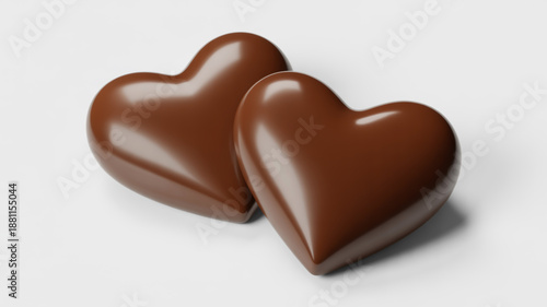 Two shiny brown heart shaped chocolates on white background