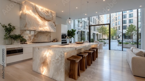 Luxurious modern kitchen island with backlit onyx and elegant wooden stools overlooking a courtyard