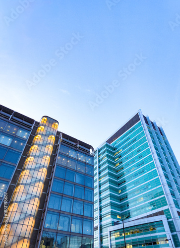 Modern London city architecture featuring glass facade office buildings against a clear blue sky