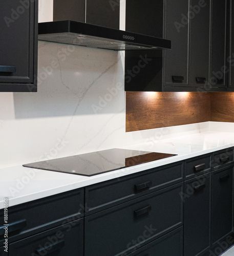 Принти на полотні Modern kitchen interior with dark cabinets, induction cooktop, white marble, and