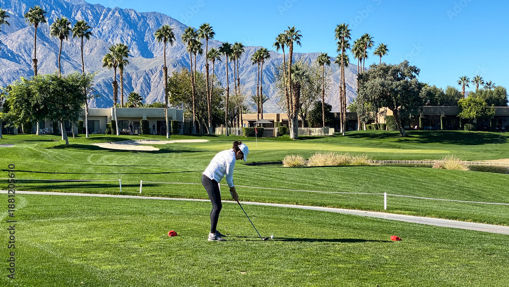 Obraz premium Woman Golfer Teeing Off on Palm Springs Golf Course