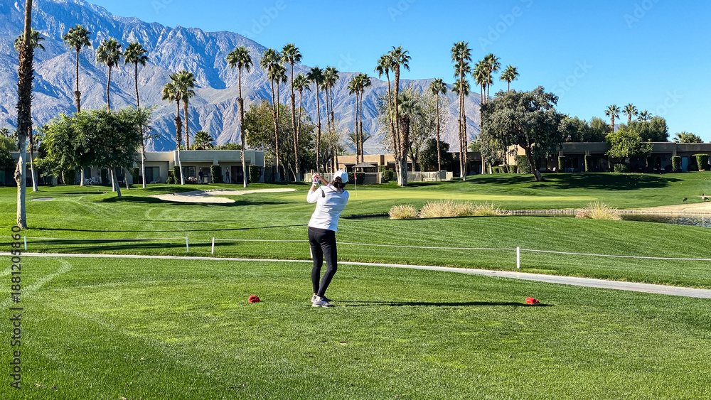 Fototapeta premium Woman Golfer Teeing Off on Palm Springs Golf Course