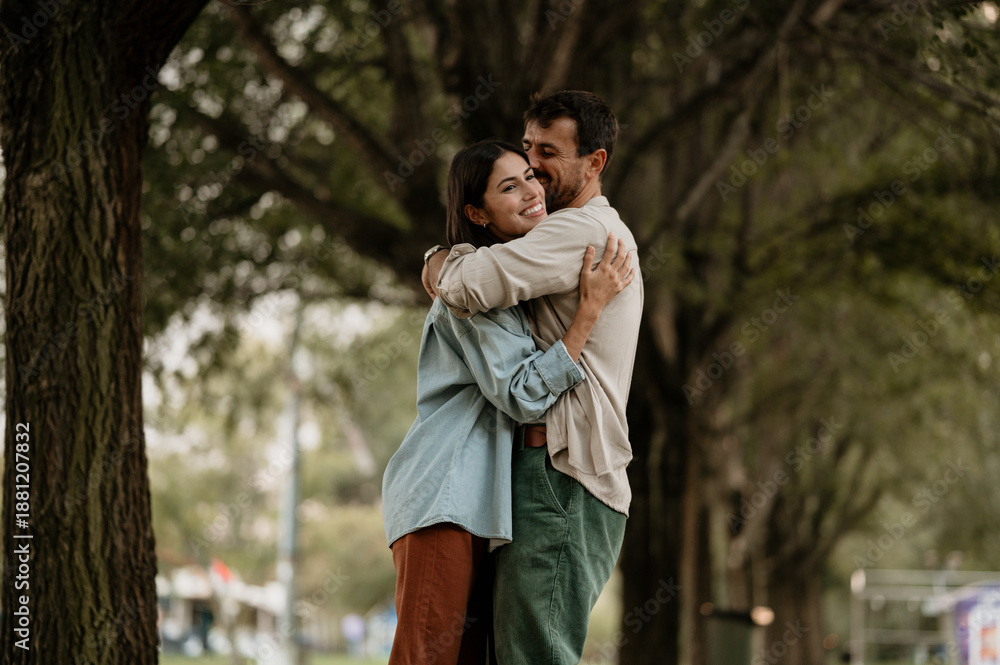 Obraz premium Happy couple embracing in park, expressing love and affection