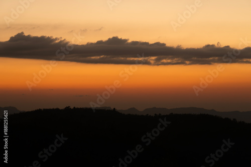 Wallpaper Mural An orange sky at sunset with dark silhouettes of mountains and clouds Torontodigital.ca