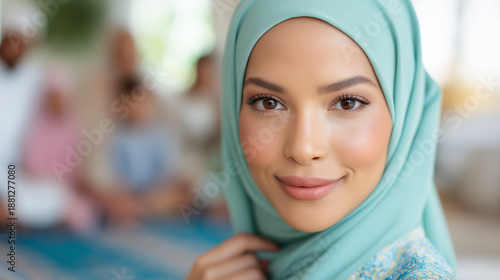 Woman in a light blue hijab smiles with her family in the background. Perfect for multicultural, family, happiness, and diversity concepts.