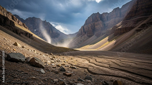 Wallpaper Mural Majestic sunlight piercing through dramatic clouds casts ethereal rays over a vast, rugged mountain valley, revealing ancient geological formations and dry streambeds Torontodigital.ca