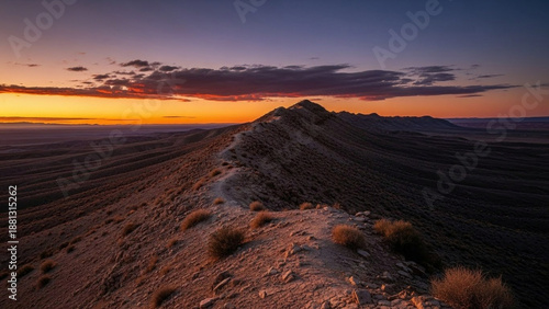 Wallpaper Mural Breathtaking sunset colors illuminate a rugged desert mountain ridge, with a winding path leading through the vast, arid landscape under a dramatic sky of vibrant hues Torontodigital.ca