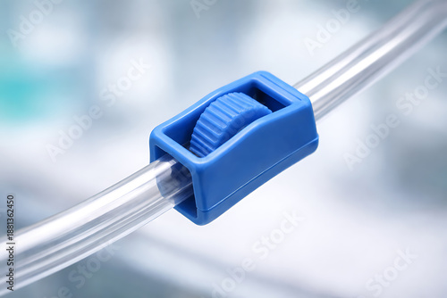 Close-up of medical iv tubing flow regulator clamp representing controlled fluid delivery systems in clinical treatment and hospital supply operations