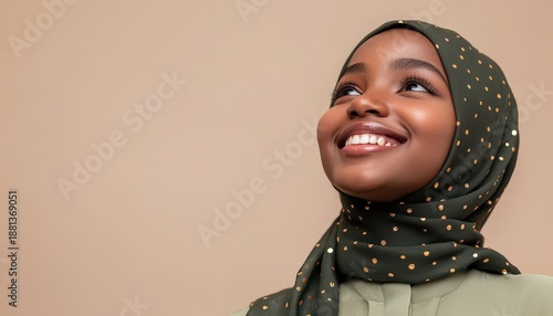 Wallpaper Mural Young African woman wearing a decorated headscarf smiles upward against a plain background Torontodigital.ca