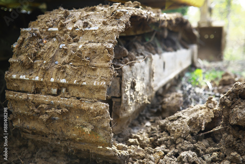 Close-Up of Muddy Excavator Tracks in Active Construction Site Environment