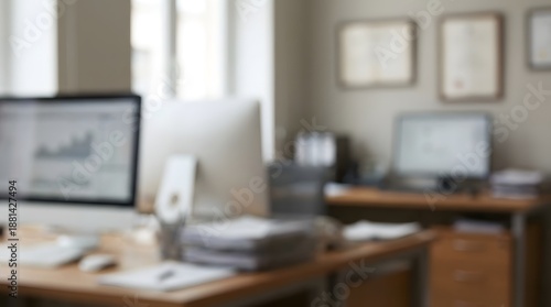 Wallpaper Mural A blurred image of a modern office desk with computers, charts, and documents, suggesting a productive workspace Torontodigital.ca