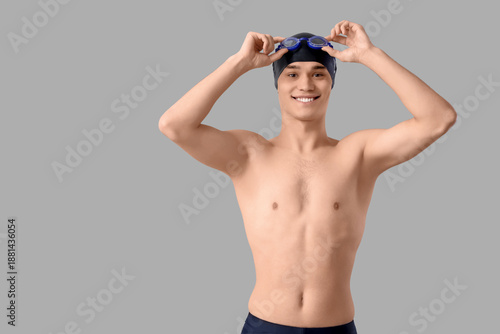 Young male swimmer on light...